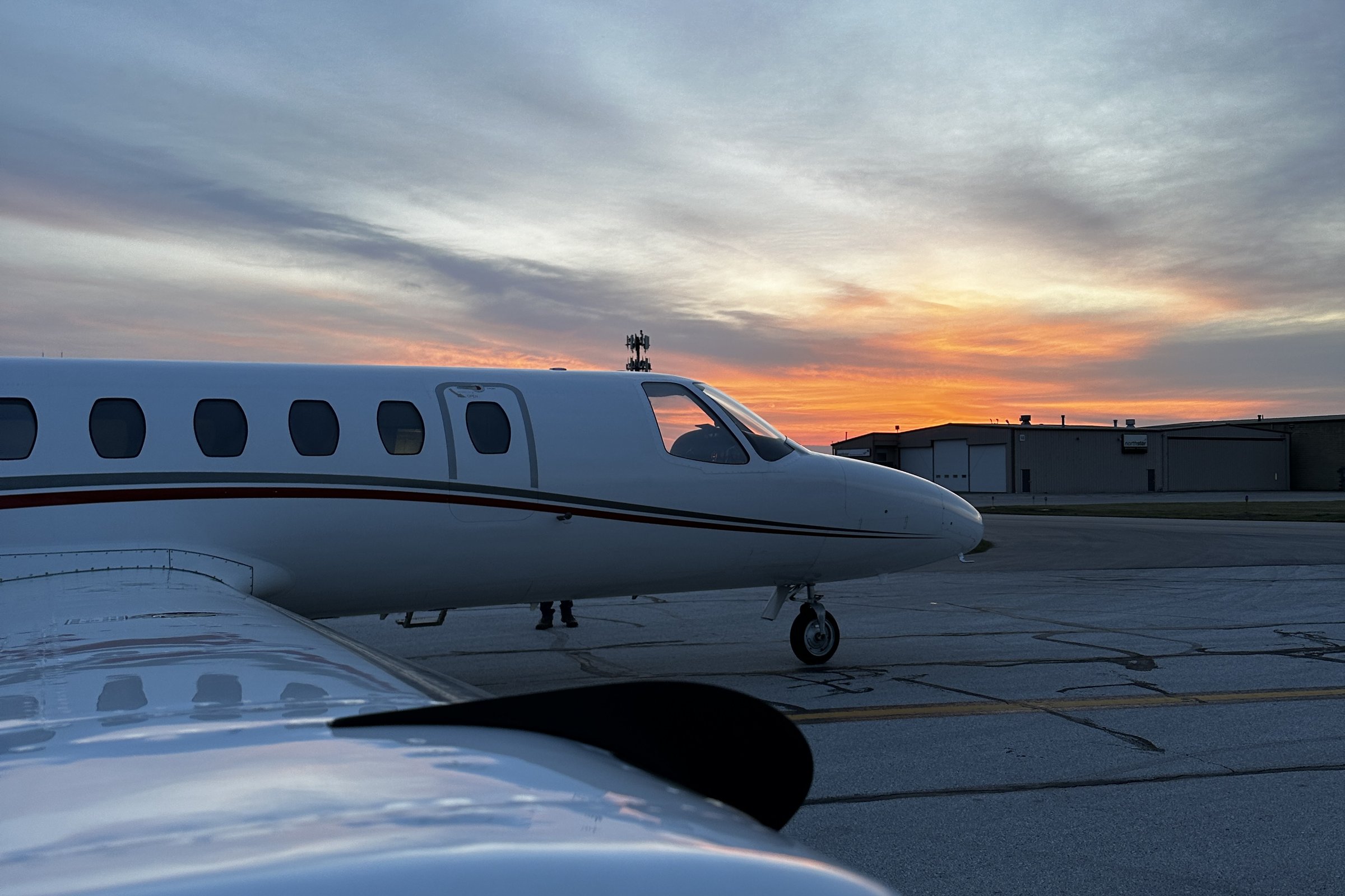Citation business jet on the ramp at sunset, shot over the wing