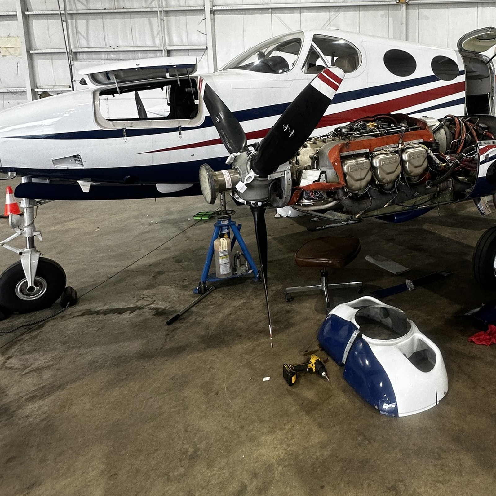 Cessna 340 with cowling off — open engine and propeller in the hangar
