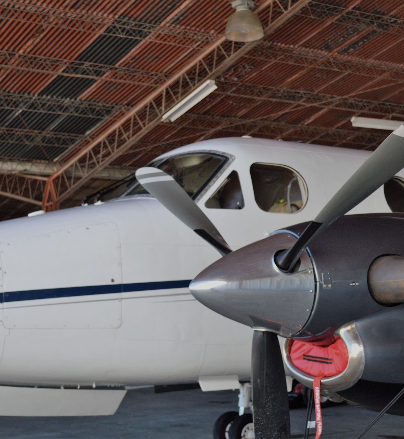 Twin turboprop propeller and nacelle under a hangar roof
